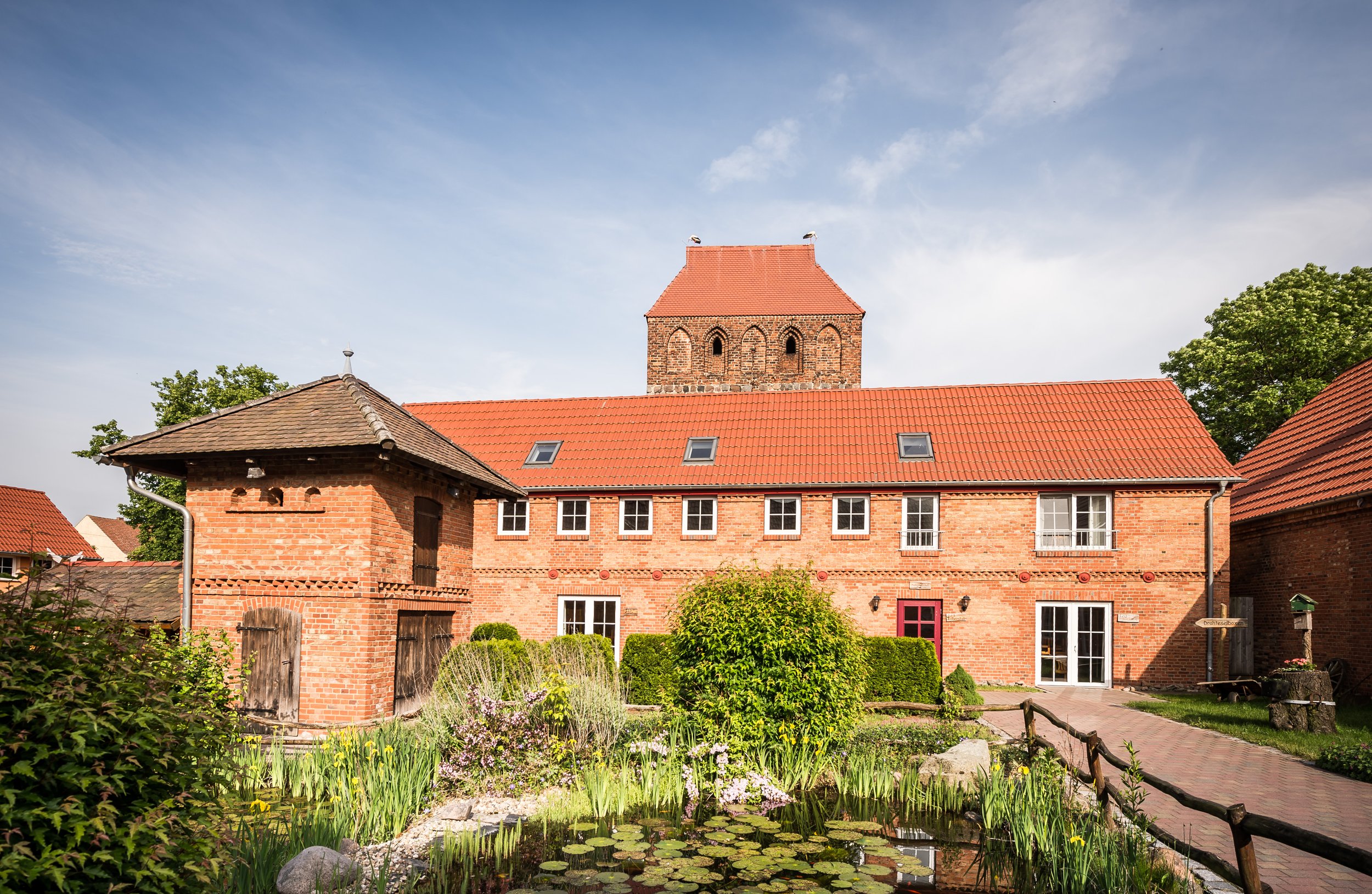 JUNE Innenhof mit Teich, Taubenturm und Terrasse des Restaurants